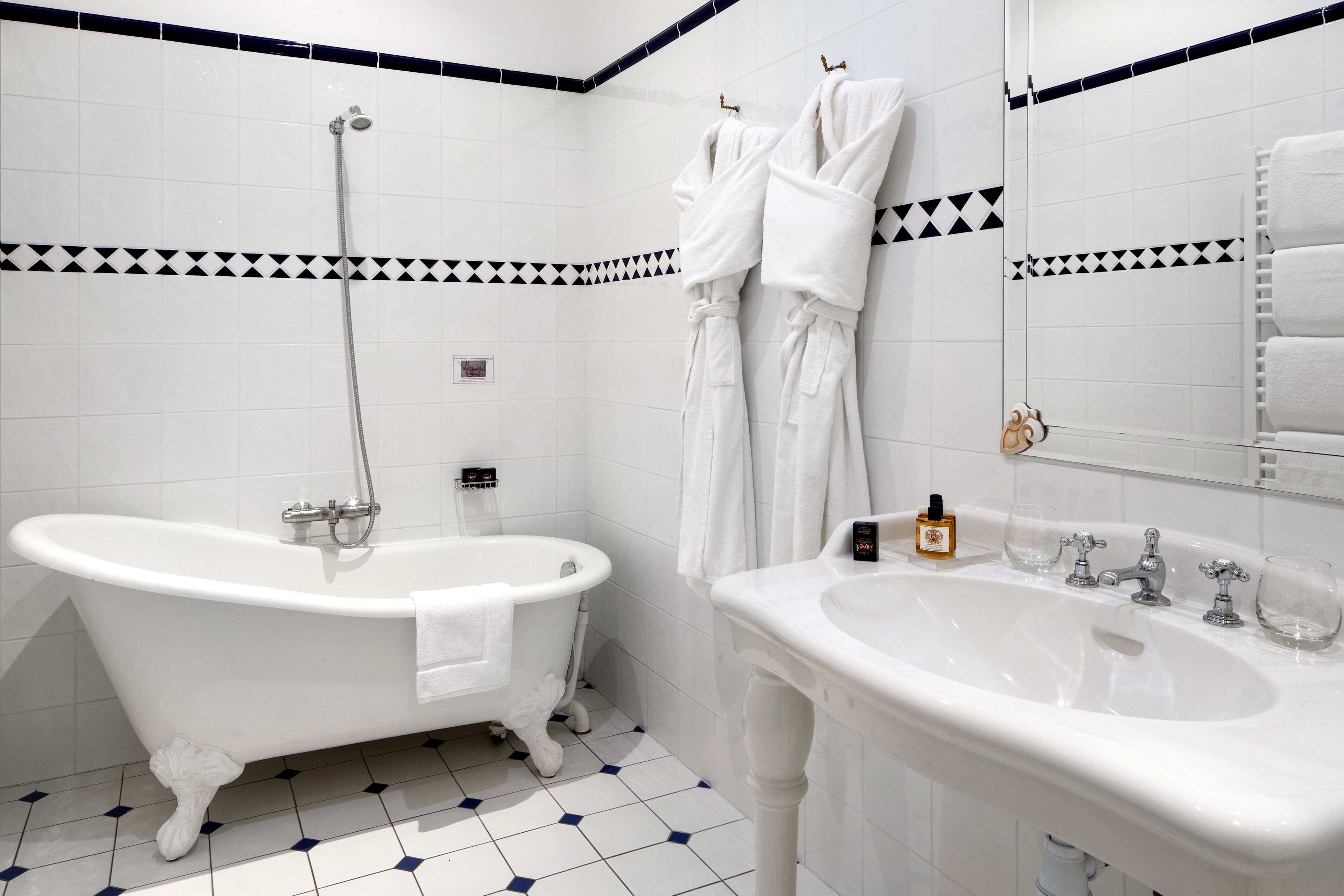 A bathroom with a clawfoot bathtub, a sink, and a mirror.