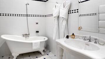 A bathroom with a clawfoot bathtub, a sink, and a mirror.