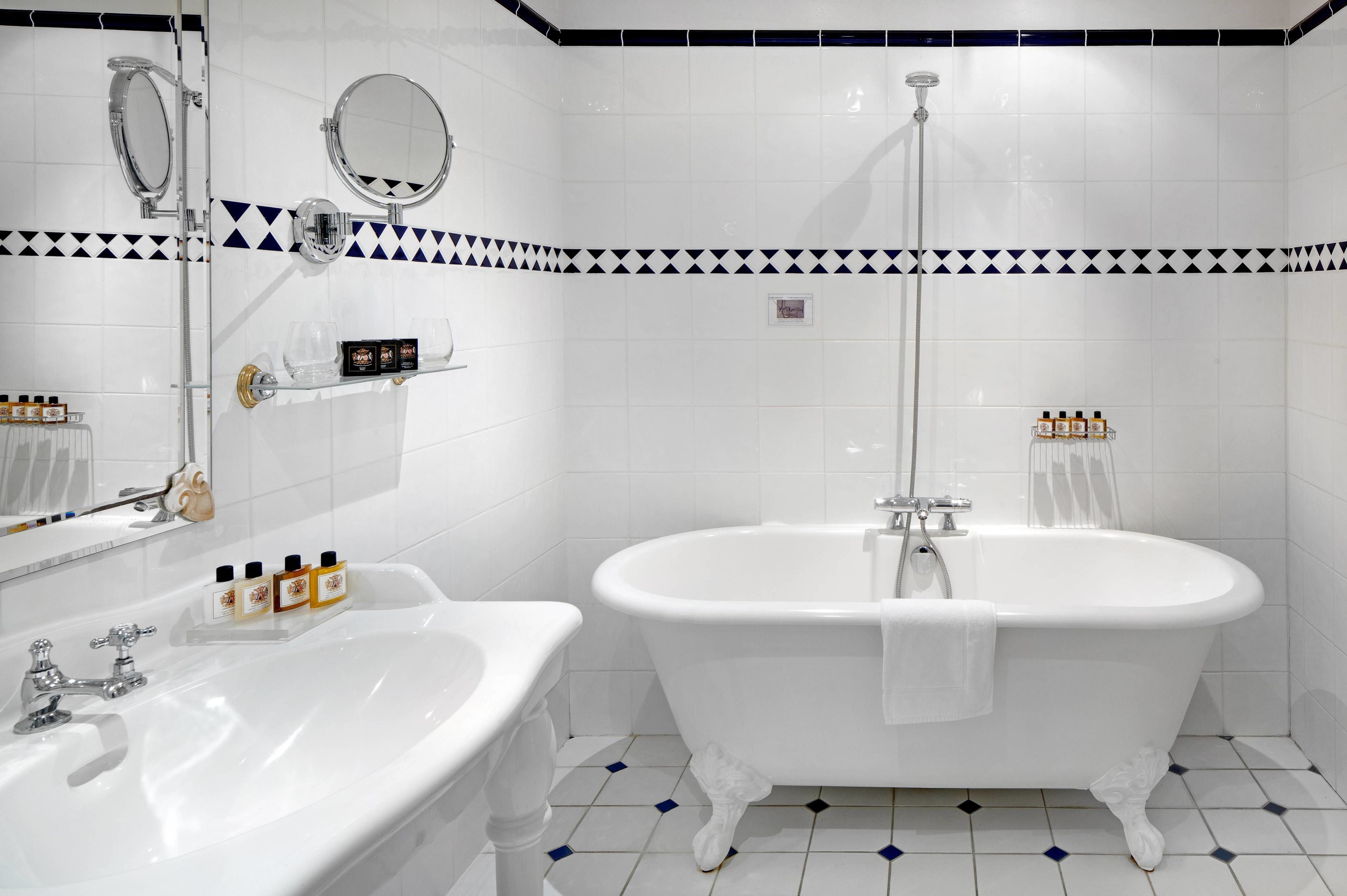 Un bany amb una banyera autònoma, un lavabo i un mirall.