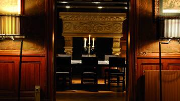 Una habitación ornamentada con chimenea, un candelabro y un piano.