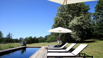 Una piscina al aire libre de temporada, sombrillas