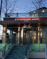 La entrada del Hotel Strangford Arms, con una puerta de cristal y una escalera que lleva a la entrada.