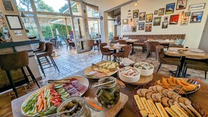 Un restaurante con diversas exhibiciones de comida, incluyendo frutas, quesos y pasteles.