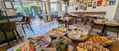 Un restaurante con diversas exhibiciones de comida, incluyendo frutas, quesos y pasteles.