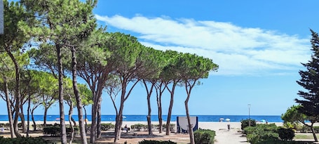 Una playa cerca, arena blanca, toallas de playa. Hôtel Le Maritime