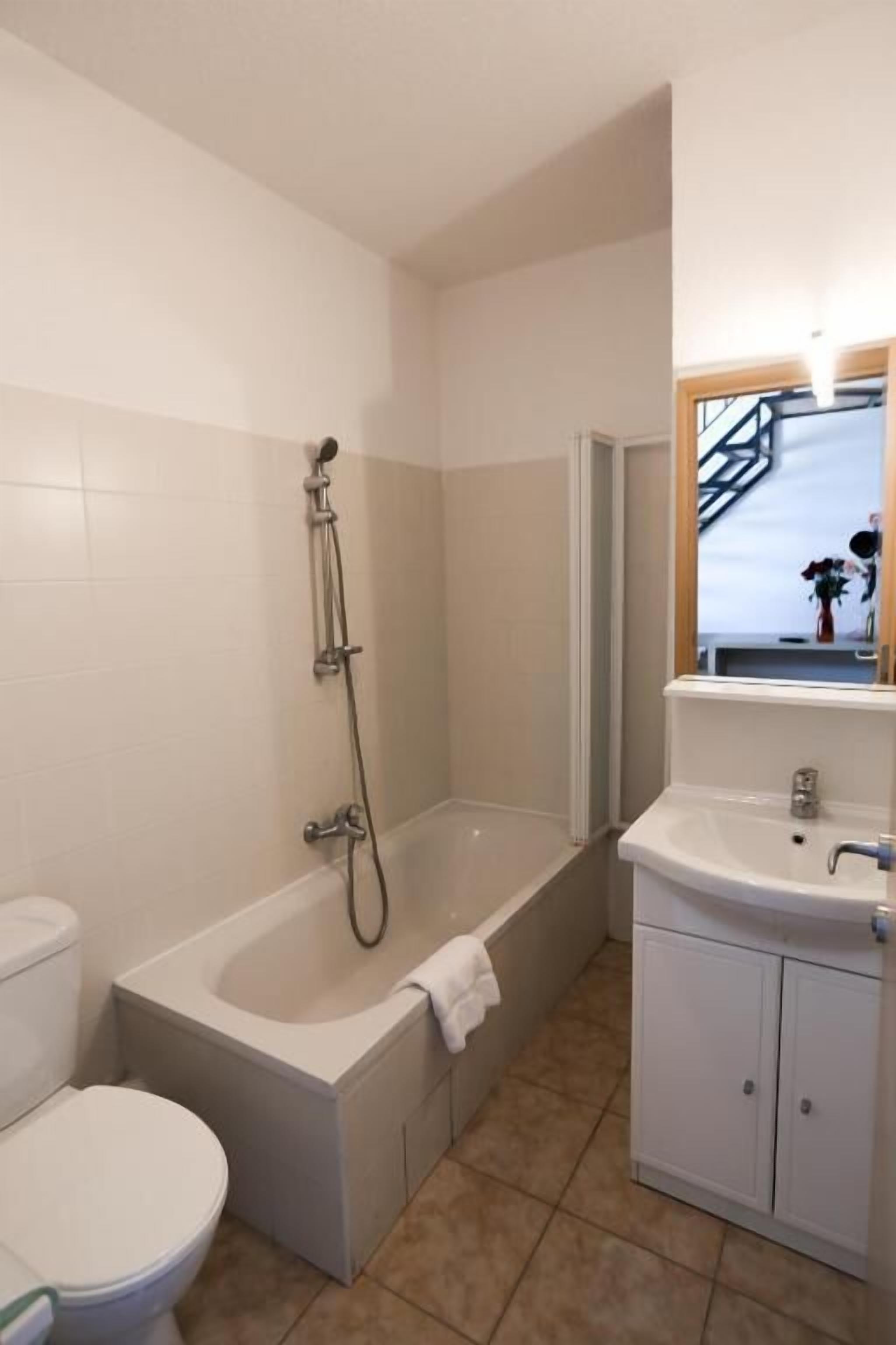 A bathroom with a toilet, a bathtub, and a sink.