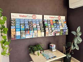 Una pared con dos carteles grandes que publicitan VisitorPoint, mostrando diversas guías de viaje y mapas.