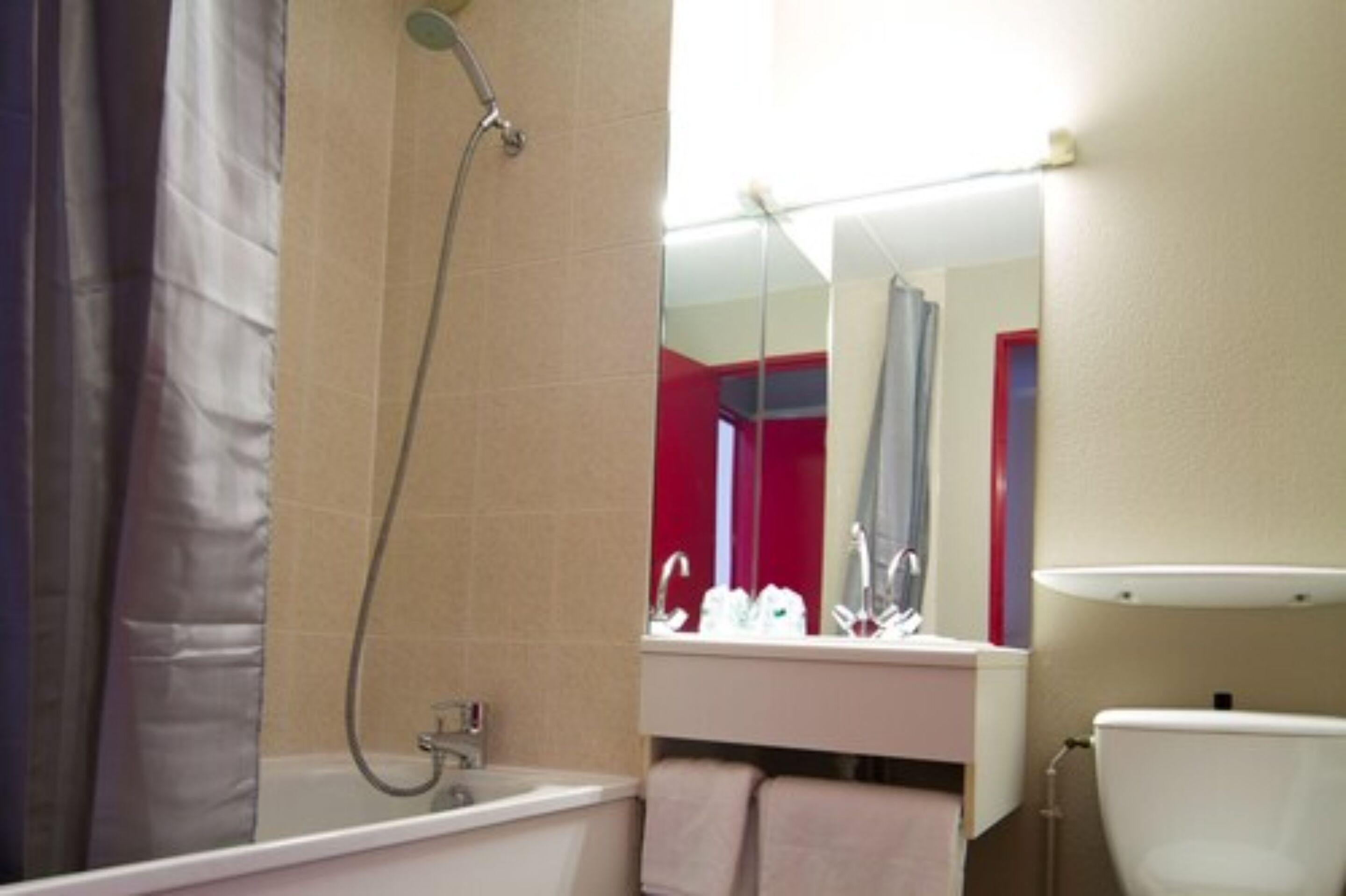 A bathroom with a bathtub, a toilet, and a sink.