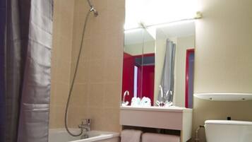 A bathroom with a bathtub, a toilet, and a sink.