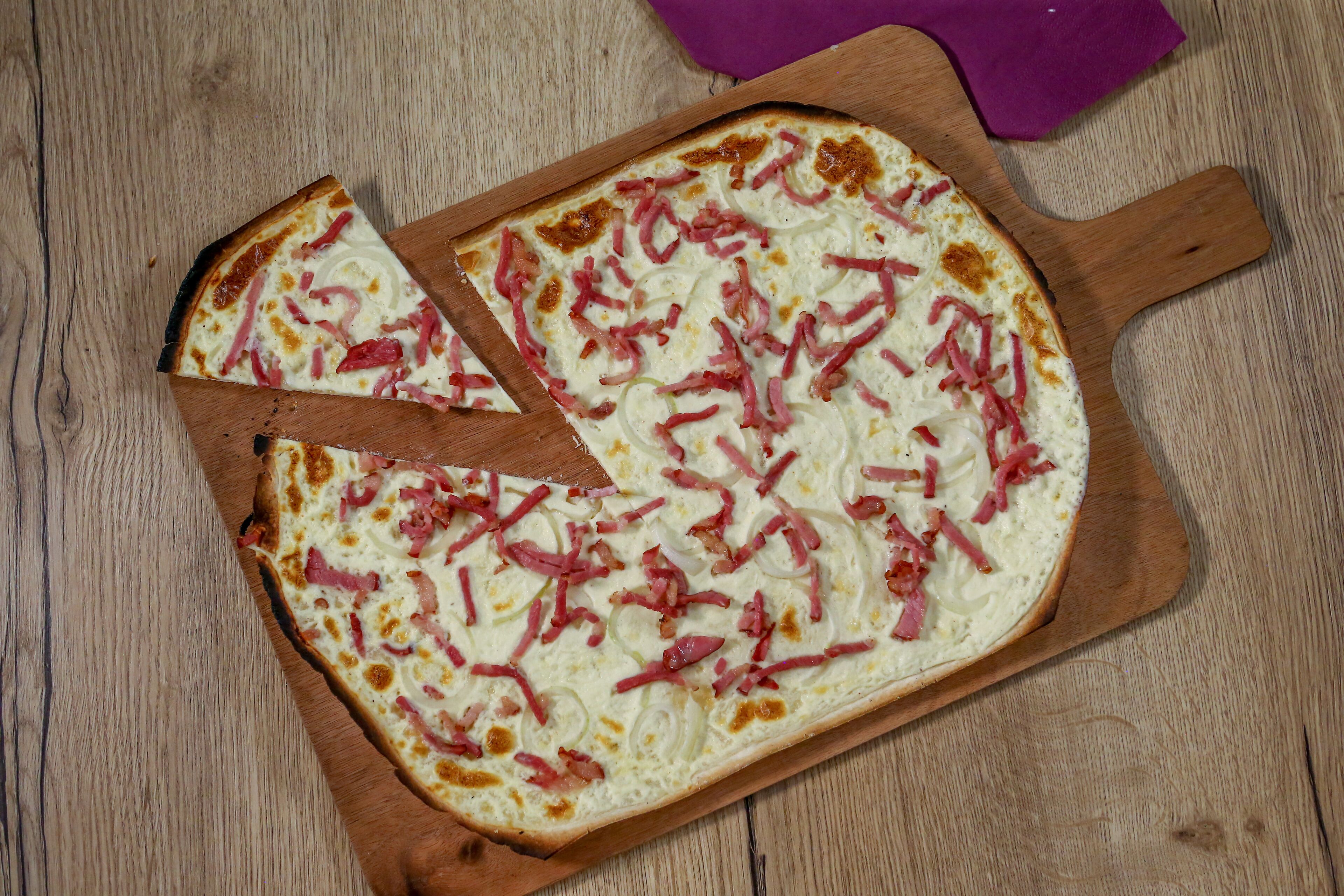 A pizza on a wooden board.