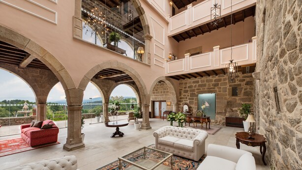 A spacious interior with a high ceiling, stone walls, and multiple seating areas.