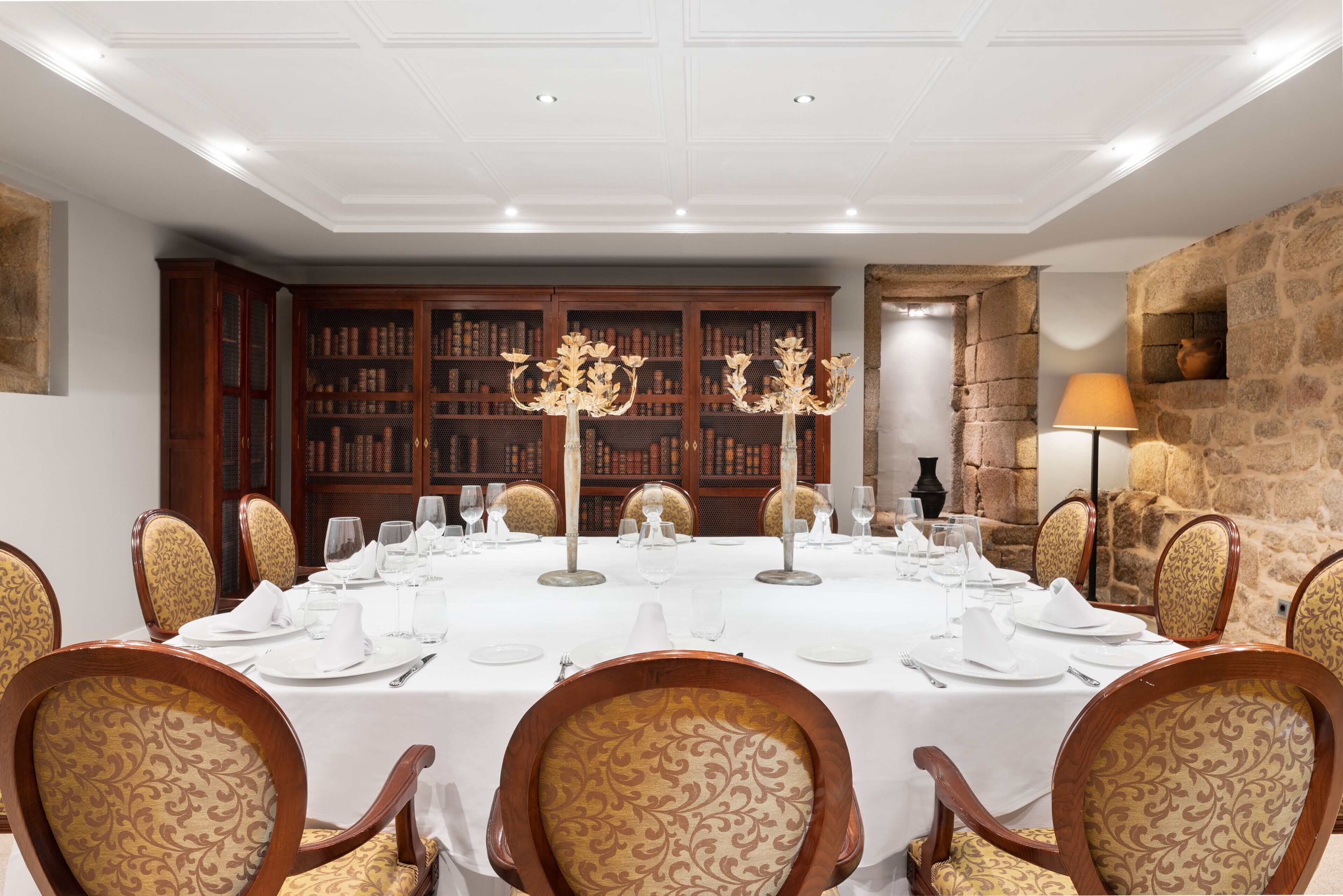 Comedor formal con una mesa redonda dispuesta para seis personas, rodeada de sillas tapizadas con estampado floral.