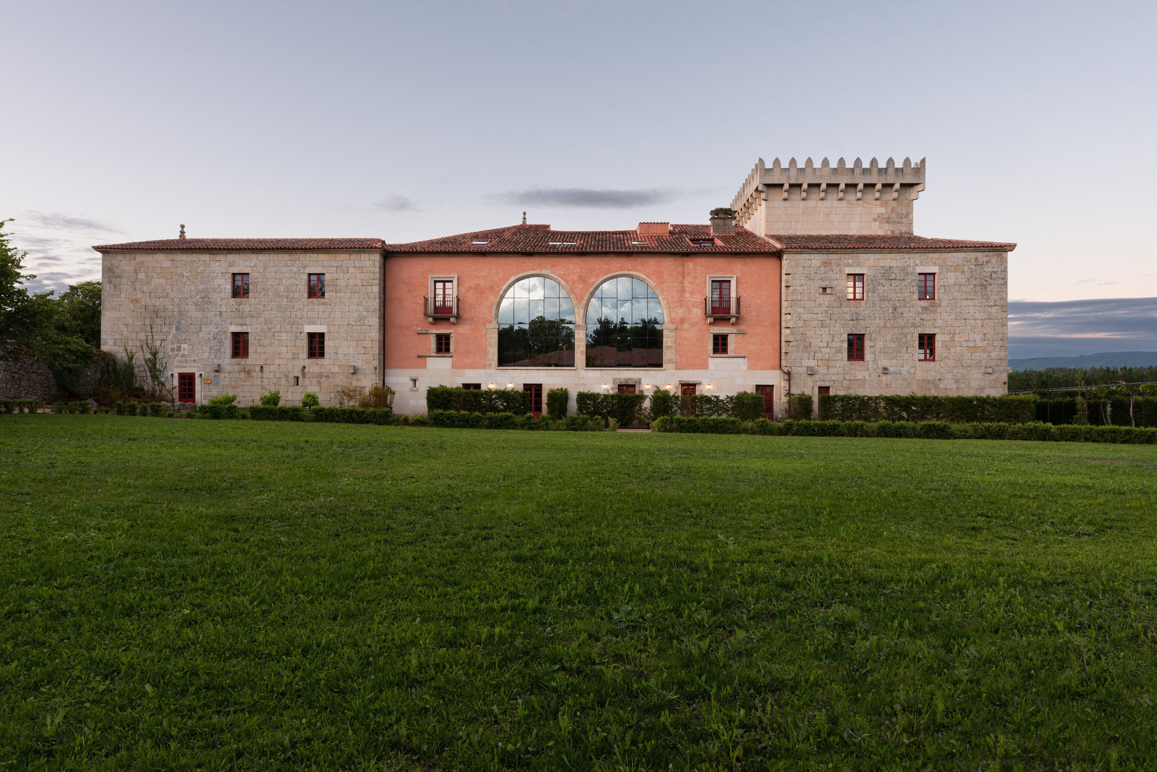 A large, historic building with a symmetrical facade, arched windows, and a central courtyard.