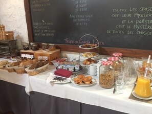 Un bufé de desayuno con diversas opciones de comida y una pizarra con poemas.