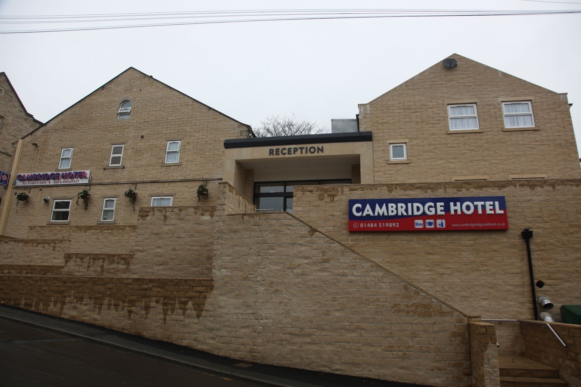En bygning med en receptionsdisk og et skilt for Cambridge Hotel.