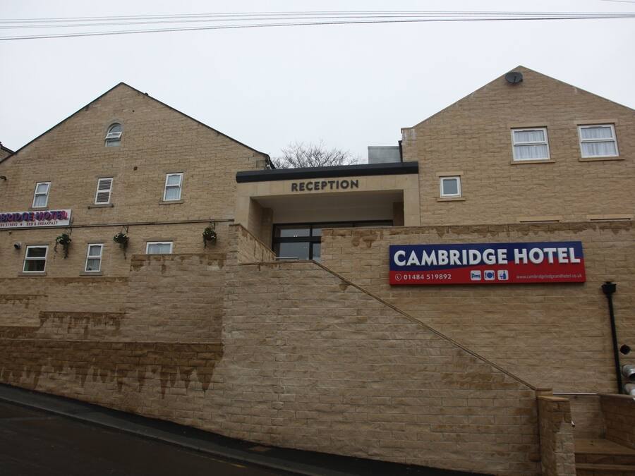 Een gebouw met een receptie en een bordje met daarop Cambridge Hotel.