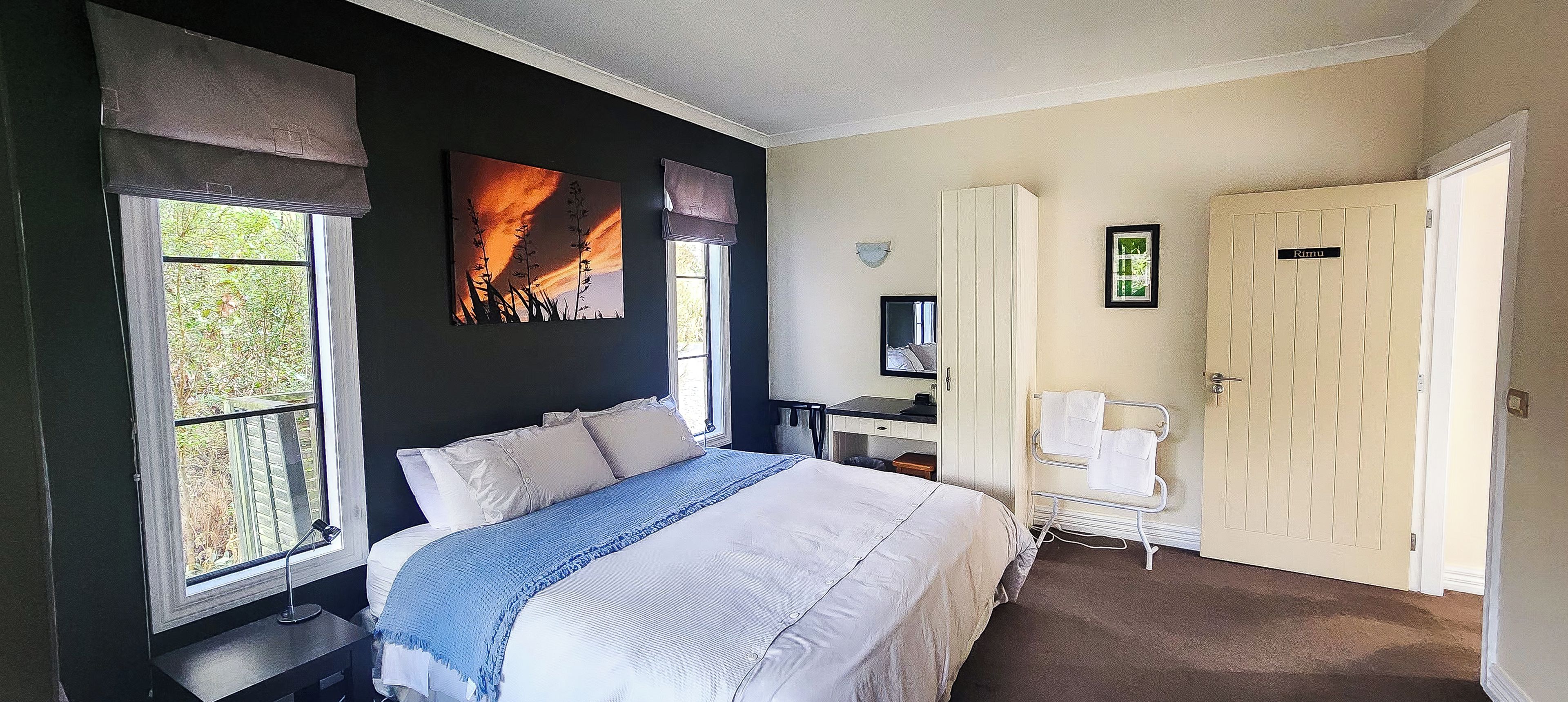 Un dormitorio con cama, escritorio, silla y armario.