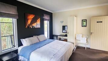 Un dormitorio con cama, escritorio, silla y armario.