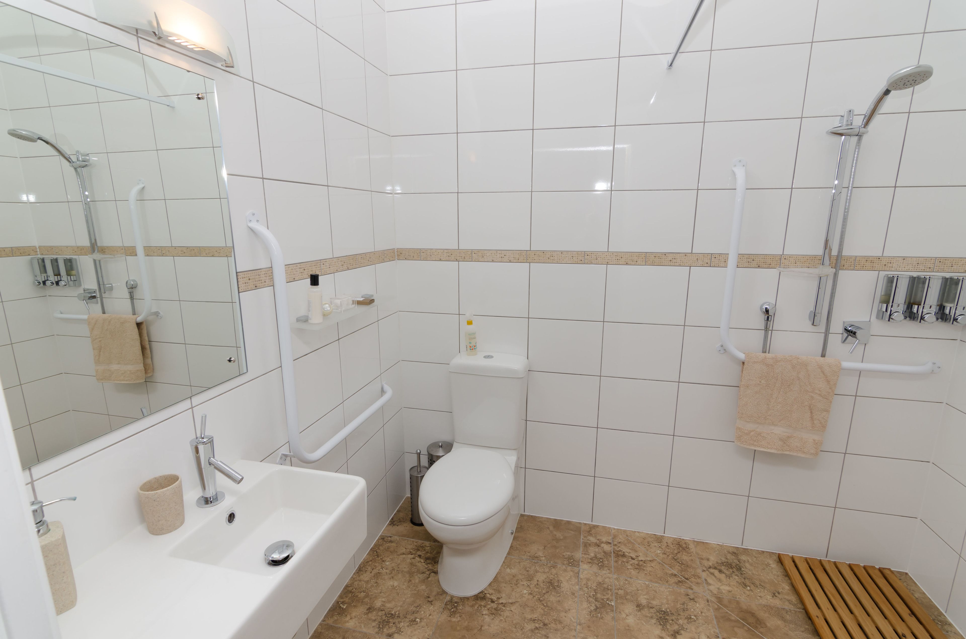 Un baño moderno con lavamanos, inodoro y ducha blancos.