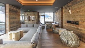 Una sala de estar moderna con un sofá modular grande, detalles de madera y una chimenea.
