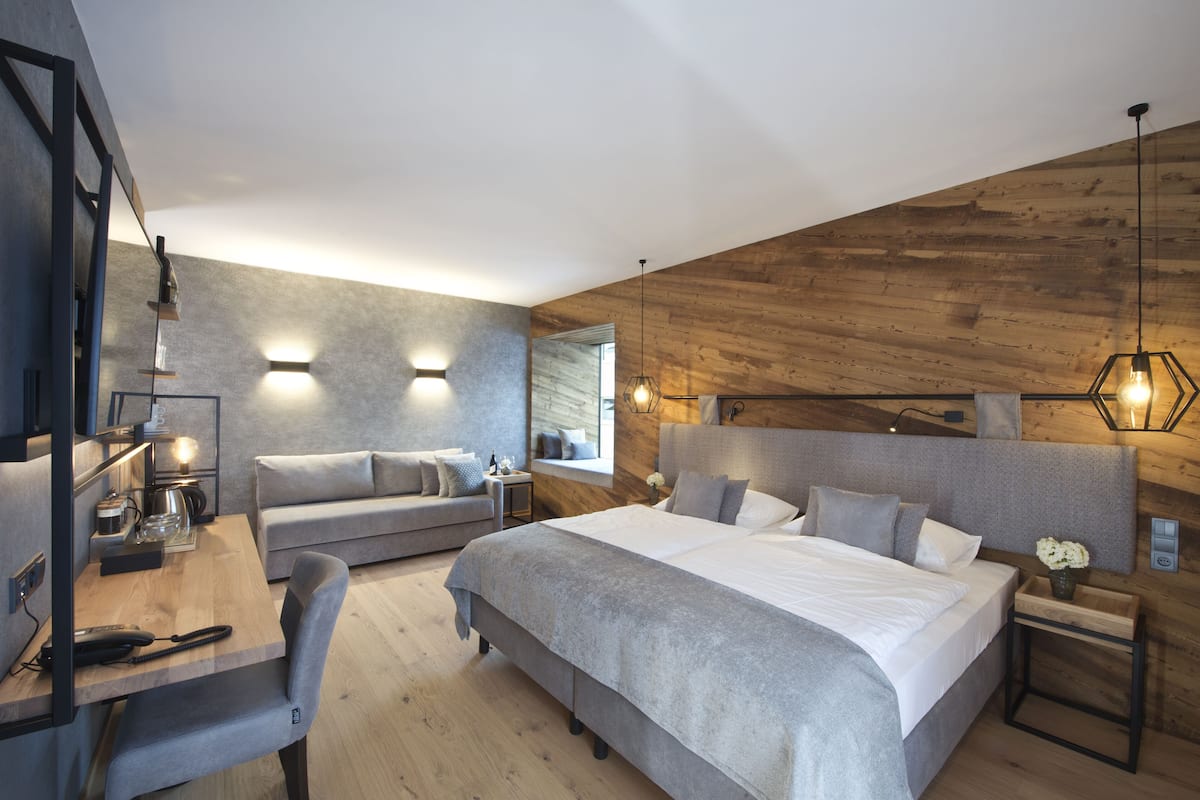 Une chambre à coucher moderne avec un grand lit, un bureau et un canapé.