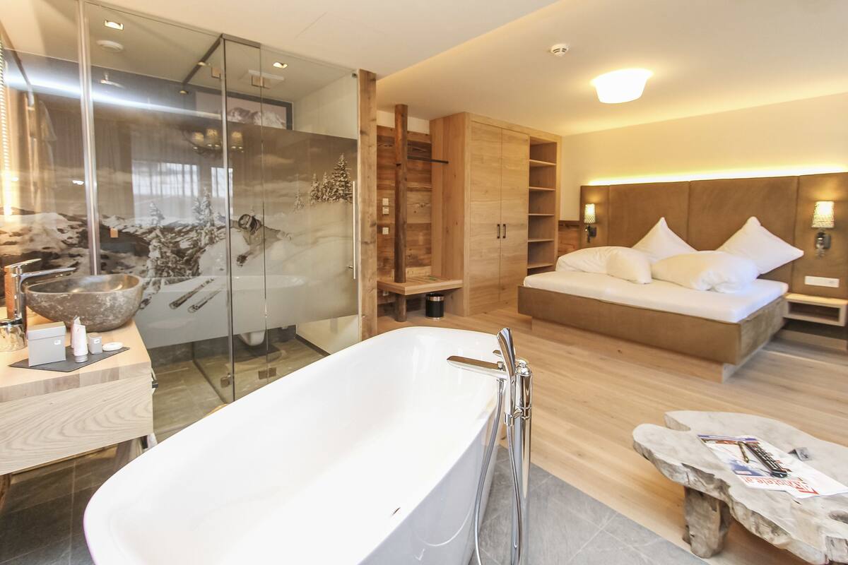 Une salle de bain moderne avec une baignoire sur pieds, une douche à parois de verre et un meuble-lavabo en bois.