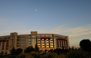 Un hotel grande de varios pisos con una fachada simétrica, múltiples balcones y una torre central.