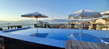 Una piscina al aire libre de temporada, sillones reclinables de piscina