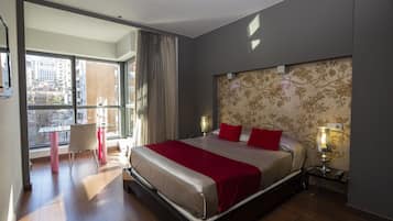 Una habitación de hotel moderna con una cama grande, un escritorio y vistas a la ciudad.