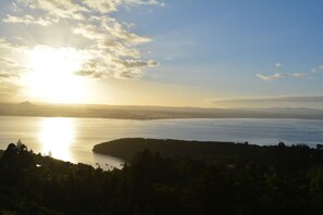A coastal landscape with a body of water, a hilly terrain, and a clear sky. - Acacia Cliffs Lodge (Taupo)