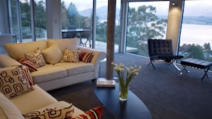 Una sala de estar moderna con sofá, mesa de centro y vistas al exterior.
