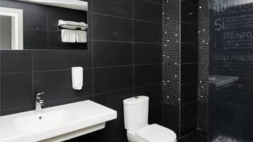 Een moderne badkamer met een wit wastafelmeubel, toilet en een handdoekhouder.