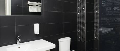 A modern bathroom with a white sink, toilet, and a towel rack.