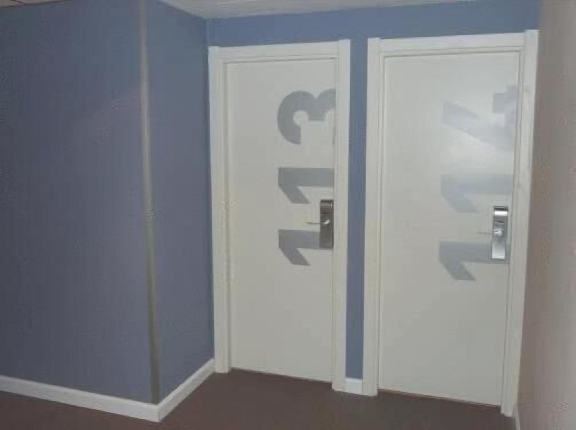 A room with two white doors, each marked with a number.