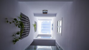 A modern interior with a glass staircase leading to a bright room. - Hostal San Francisco (Seville)