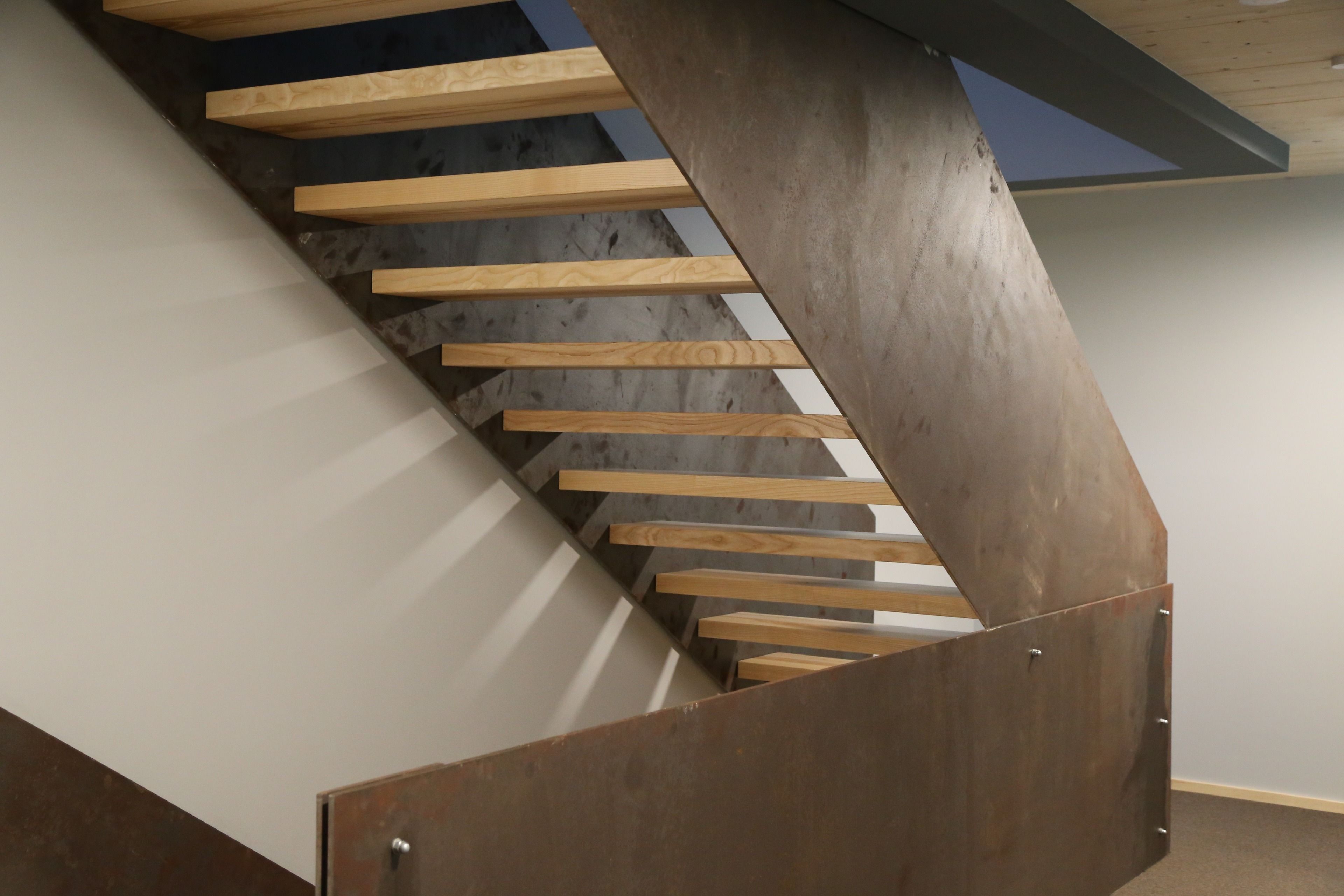 Una escalera de madera con barandales de metal.