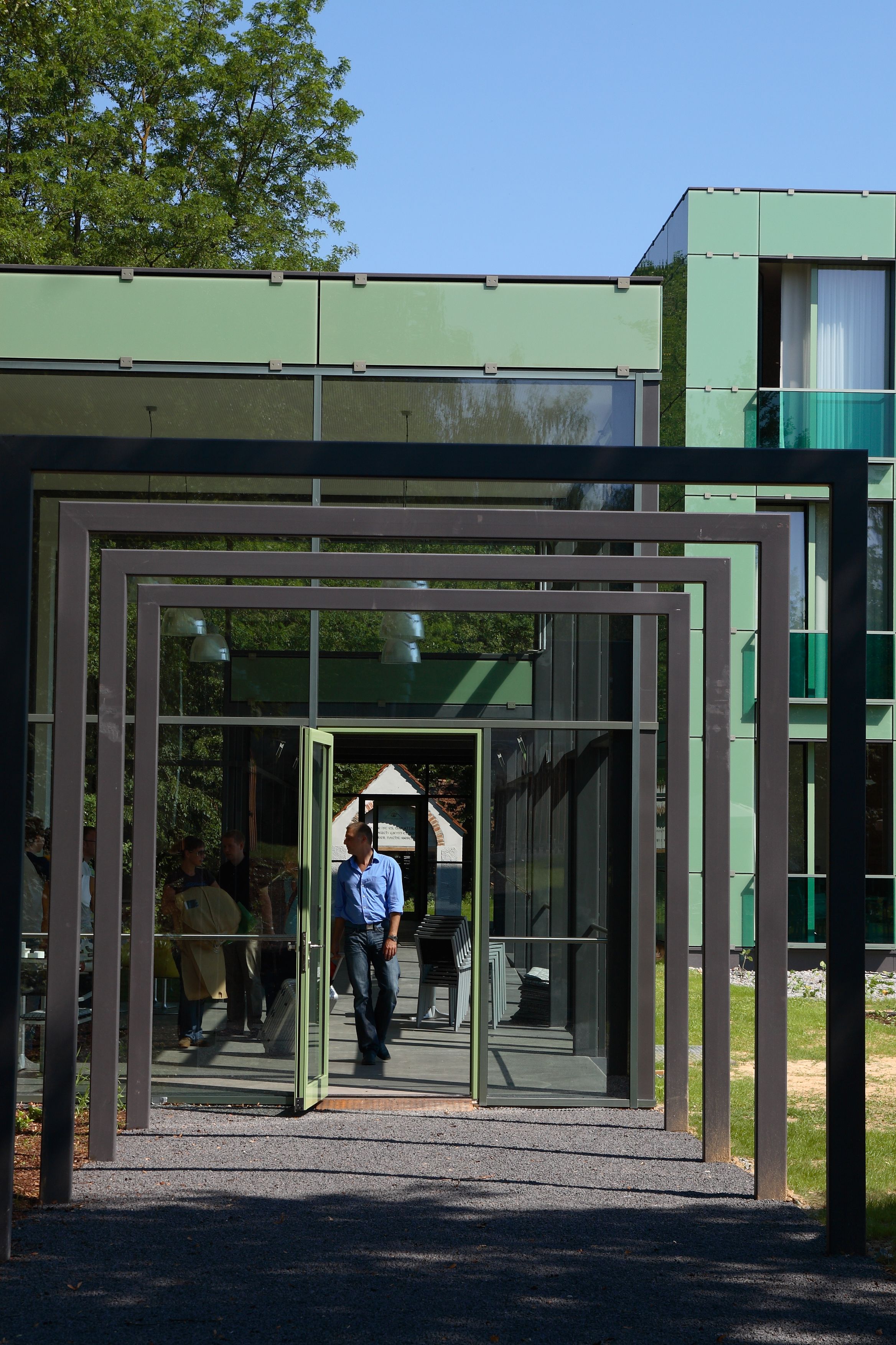 Un edificio moderno con entrada de vidrio y estructura de armazón metálico.