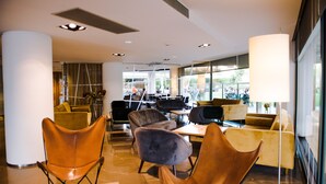 A modern interior with leather chairs, a table, and a large window providing a view outside. - Gran Hotel Victoria (Santander)