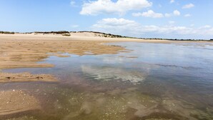 Een strand met helder ondiep water en een zandkust.
