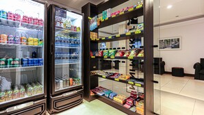 A vending machine stocked with snacks and drinks, and a shelf with packaged goods.