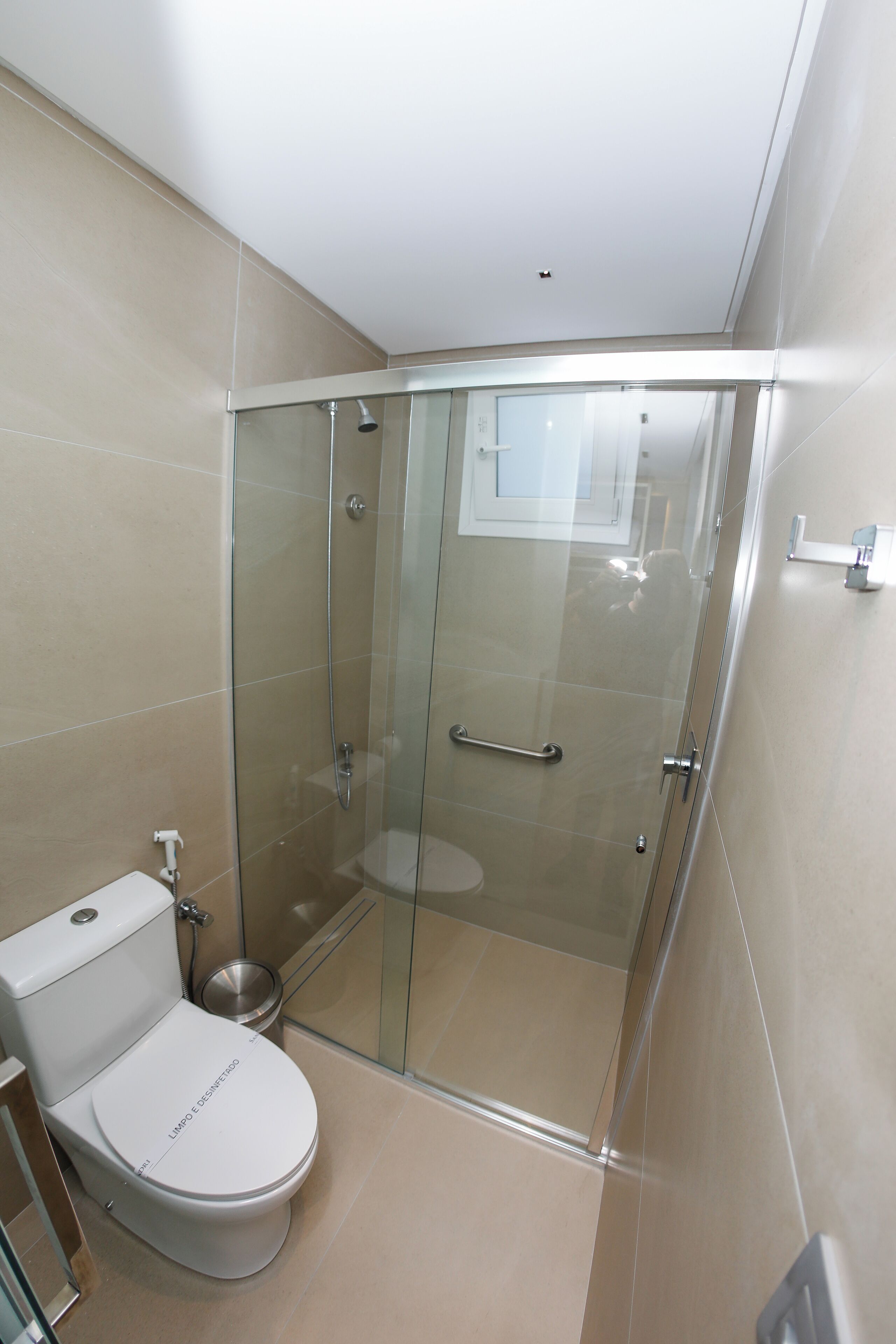 A modern bathroom with a glass-enclosed shower, a toilet, and a bidet.