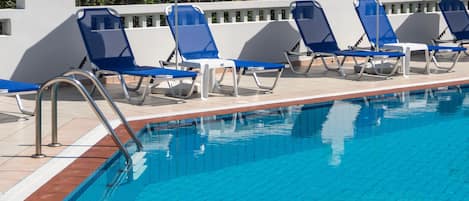 Piscine extérieure en saison, parasols, chaises longues