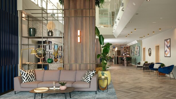 A spacious lobby with a modern sofa, coffee table, and potted plants. - voco Venice Mestre - The Quid by IHG (Mestre)