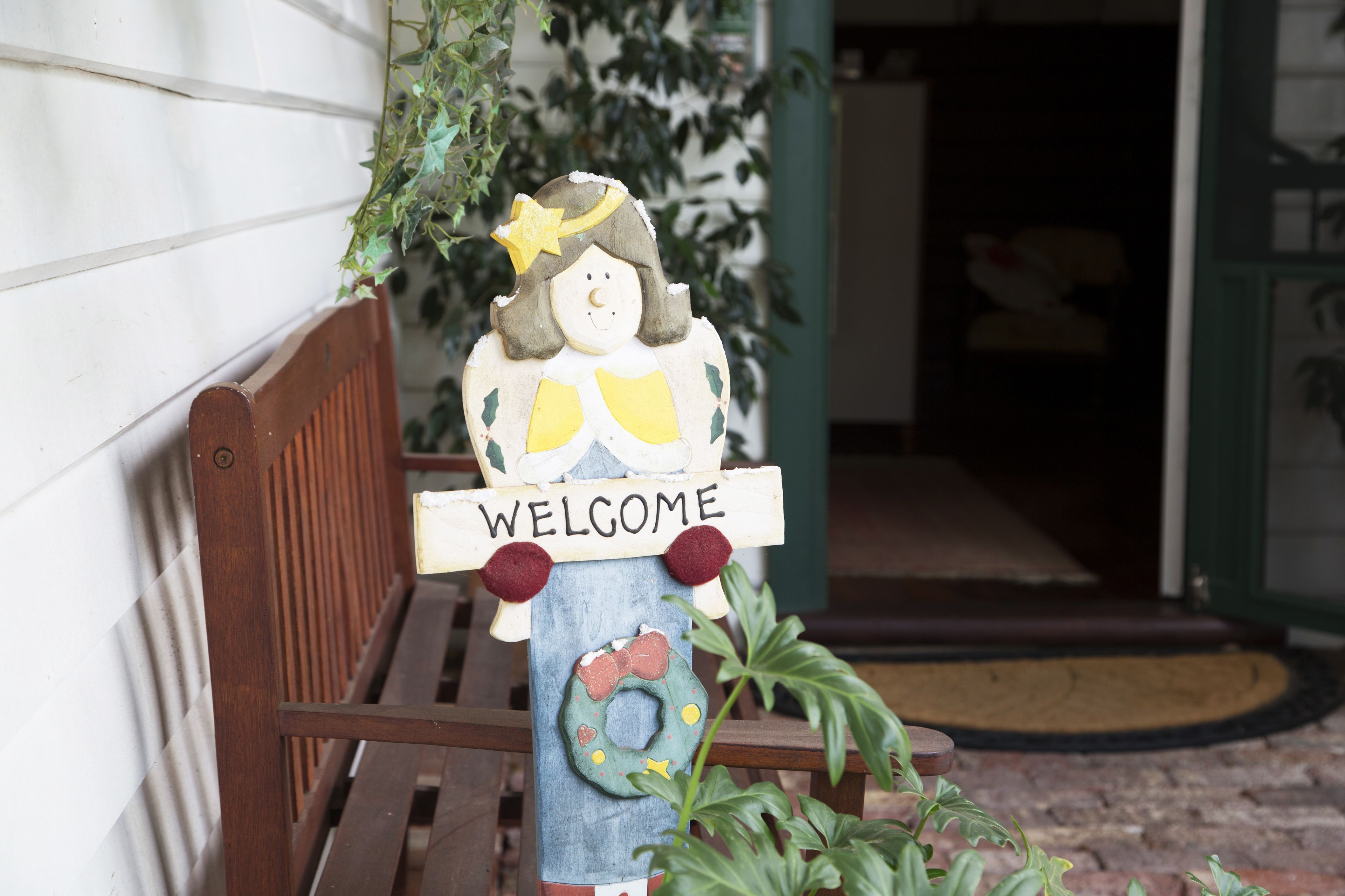 A wooden bench with a 'WELCOME' sign and a decorative figure.