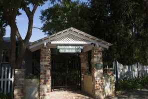 A gated entrance to Rosebridge House with a sign indicating it offers bed and breakfast services. - Rosebridge House Bed & Breakfast Adult Retreat (Gooseberry Hill)