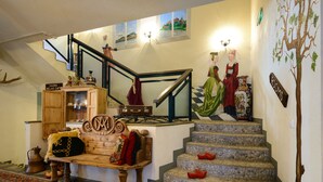 A staircase with a checkered floor, a wooden bench with cushions, and a sign indicating a sauna and relaxation cafe. - Hotel Hansalinn (Parnu)