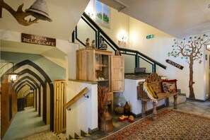 A staircase leading to a room labeled "SAUNA RELAX CAFE" with a wooden bench and decorative items. - Hotel Hansalinn (Parnu)