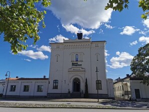 Un edificio blanco con el letrero "Hotel Fünfhaus" y una puerta con la leyenda "EAST GATE".