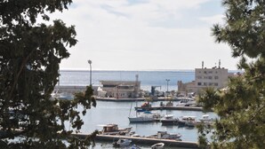 A marina with boats docked, a building with a sign, and a clear view of the water. - Oaza (Budva)