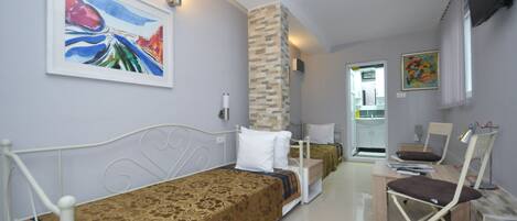 Una habitación de hotel con cama, escritorio, silla y televisión.